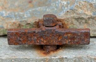 Rusty metal bolt and nut on a concrete surface photo