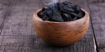 Smoldering charcoal in a wooden bowl photo
