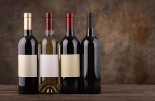 Assortment of red and white wine bottles on wooden table photo