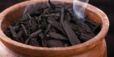 Smoldering charcoal in a wooden bowl photo