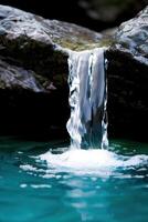 Cascading waterfall flowing into serene turquoise pool photo