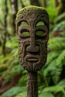 Moss covered ancient tribal mask in the jungle photo