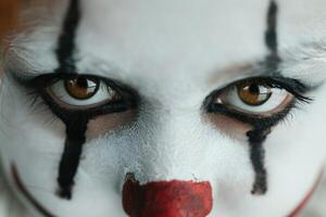 Creepy clown face with intense eyes and red nose photo