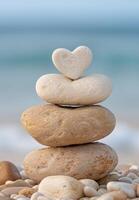 Stacked stones with heart shaped rock on top photo