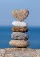 Balanced stones and heart shaped rock on the beach photo