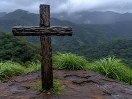 Wooden cross on a rocky mountain path with lush green vegetation photo