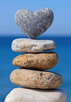 Stacked stones with heart shaped rock on top photo