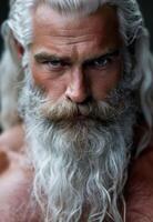 Weathered face of an elderly man with a long, white beard photo
