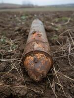 Rusty pipe lying on muddy ground photo