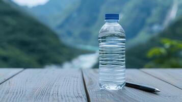 Bottle of water on wooden table with mountain landscape photo