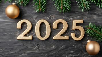 new year 2025 golden numbers on dark wooden background with christmas tree branches photo