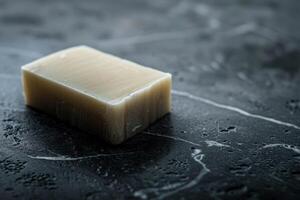 Handmade soap bar on dark surface photo