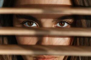 Mysterious womans eyes peeking through blinds photo