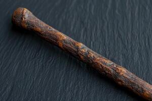 Closeup of a rustic wooden stick on a dark background photo