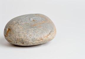 Smooth river stone on white background photo