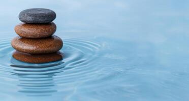 Stacked zen stones in calm water photo