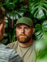 Bearded man in green cap surrounded by lush foliage photo