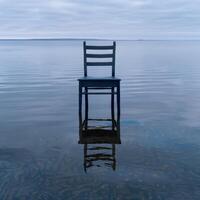 Serene lake with a lone chair photo