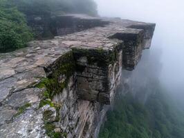 Mysterious stone path leading to misty cliff edge photo