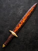 Fiery fantasy sword on dark background photo