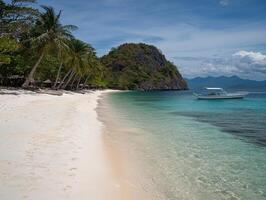 Tropical beach with crystal-clear water, white sands, and palm trees swaying in the breeze photo