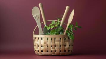 A still life image of a wicker basket filled with various kitchen utensils and fresh herbs on a solid burgundy background. photo