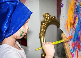 Smiling young boy with paint on his hands and face photo