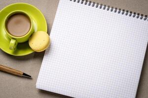 blank spiral notebook with grid paper, flat lay with coffee on textured art paper photo