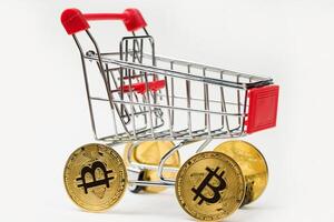 Grocery cart with Bitcoin wheels. The concept of technological breakthrough, online shopping. photo