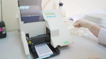 Automated equipment in the laboratory. Modern machine for making sample researches. Medical worker controls the work of robotic machine. video