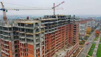 Construction site of modern skyscraper. Aerial side view on a new high-rise building in a new residential complex of a megacity. video