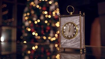 Nice clock on blur christmas background. Clock is showing midnight. It's twelve o'clock. Happy new year time. Christmas concept video