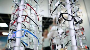 Close-up of fashionable eyeglasses in the optical shop. Spectacles of different colors and shapes nicely placed on the stand. Ophthalmology. video