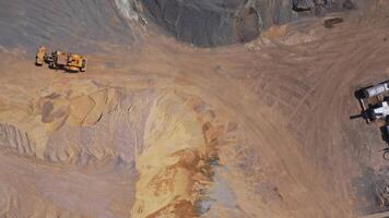 Bulldozer on a quarry. Aerial view of industrial machine working on a huge territory with piles of sand and crushed stones. Motion camera around. video