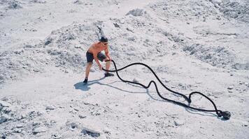 Aerial shot of a man working out with battle ropes. Bodybuilder posing outdoors. video