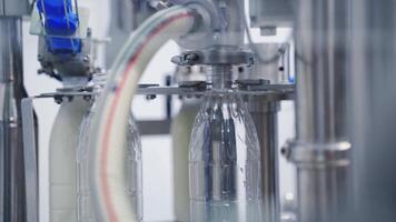 Automated technology of bottling milk in robotic factory. Plastic bottles are filling with milk by modern machinery at a dairy plant. Close-up. video