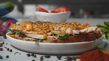 Bright and intense flame of a gas stove melts the grated cheese placed on a slice of toast. cook prepares a sandwich consisting of chicken, salad and cheese. Close up. Slow motion video