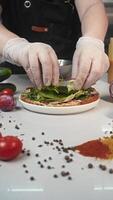 Chef adds lettuce leaves and various herbs to the bruschetta in order to increase its nutritional value and make the dish dietary. Vertical video