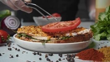 Sandwich with processed cheese, meat and vegetables. it is decorated with thinly sliced tomato slices, which turn out juicy and appetizing. video