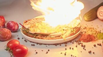 Chef of restaurant prepares large burger with cheese. He grates cheese and melts it using special cooking tool, creating deliciously creamy texture that flows down inside of sandwich. Slow motion video