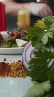 Delicious vegetable salad featuring bacon, prepared by chef, is sprinkled with grated Parmesan cheese during cooking process in kitchen of high-end restaurant. salad is salted video