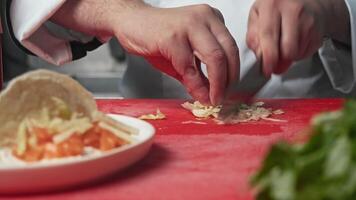 Skilled hands of chef cut iceberg lettuce into small pieces for use in preparation of gyros, which are served with pita bread and fish or seafood. video