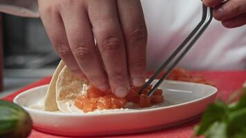Chef and baked salmon under a tortilla covered with cheese cream create a unique variation of the traditional Mexican dish - tortilla with red fish video