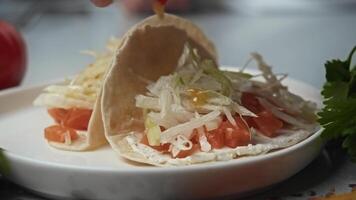 Mexican taco, in its open form, is topped with a spicy orange honey sauce, giving it a unique flavor. Close up video