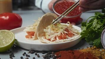 Red caviar is added to a taco dish featuring salmon and other types of red fish, creating a unique seafood experience video