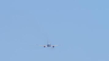 Footage of an aircraft with an unrecognizable livery climbing after takeoff, long shot, rear view. Airplane departure. Passenger flight leaving video
