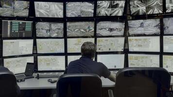 Security officer controls CCTV cameras in office, uses digital tablet and computers. Media. High tech software showing surveillance cameras, concept of social safety. video
