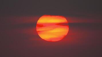 A huge red sun in a dark cloudy sky. Scenic view of orange sky during sunset video