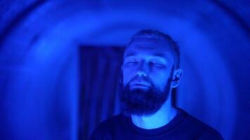 Portrait of a young stylish hipster man rapper moving and posing to the camera. Media. Neon lighting background creating effect of spinning tunnel. video