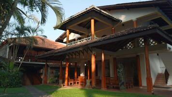 Luxury cottage with lush green bushes and long coconut trees. Action. Concept of summer vacation. video